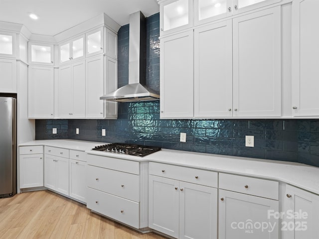 709 Cavesson Way, Monroe, NC 28110 - kitchen with wall chimney range hood, stainless steel appliances, light wood-type flooring, light countertops, and white cabinets