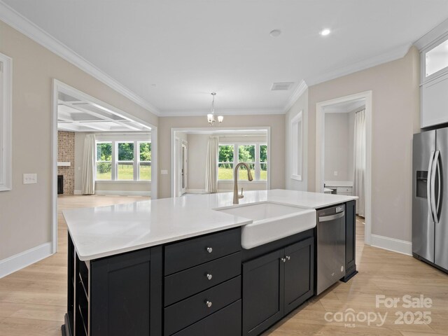 709 Cavesson Way, Monroe, NC 28110 - kitchen with appliances with stainless steel finishes, light wood-type flooring, light countertops, a center island with sink, and crown molding