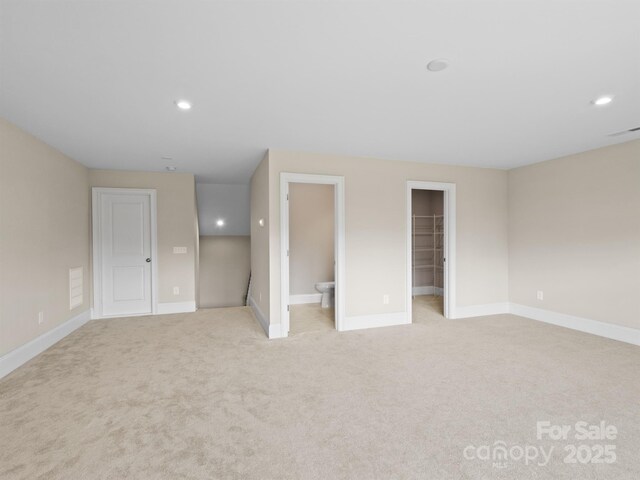 709 Cavesson Way, Monroe, NC 28110 - unfurnished bedroom featuring light carpet, a spacious closet, recessed lighting, connected bathroom, and a closet