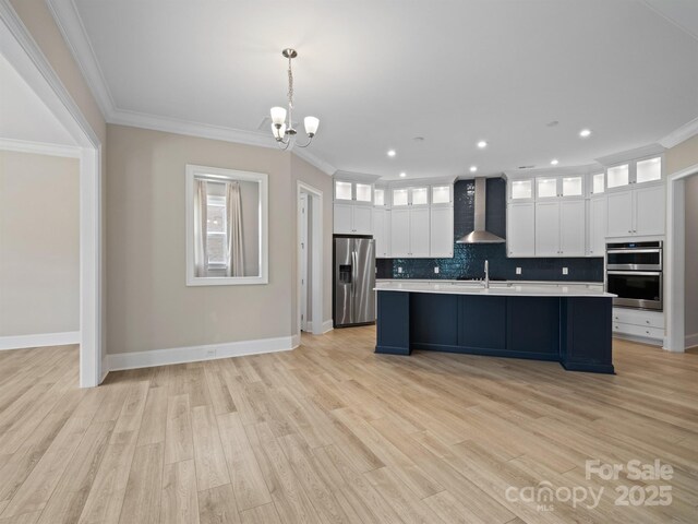 709 Cavesson Way, Monroe, NC 28110 - kitchen featuring appliances with stainless steel finishes, wall chimney range hood, light countertops, a chandelier, and white cabinets