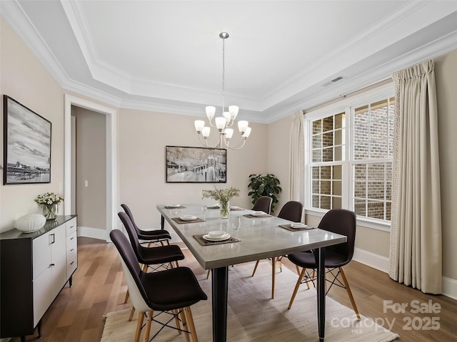 709 Cavesson Way, Monroe, NC 28110 - dining space with a tray ceiling, a chandelier, wood finished floors, and ornamental molding