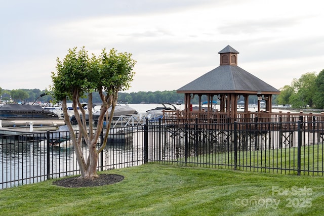 exterior space featuring a water view, a gazebo, and fence