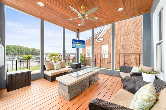 sunroom / solarium featuring wooden ceiling, an outdoor hangout area, hardwood / wood-style floors, and a ceiling fan