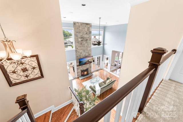 stairway with crown molding, wood finished floors, baseboards, and ceiling fan