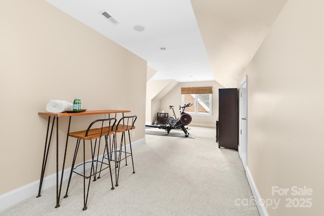 interior space with baseboards, visible vents, carpet, and vaulted ceiling