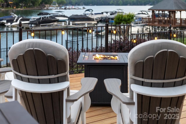 balcony featuring an outdoor fire pit and a water view