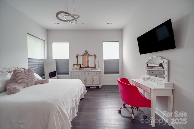 bedroom with dark wood finished floors and baseboards