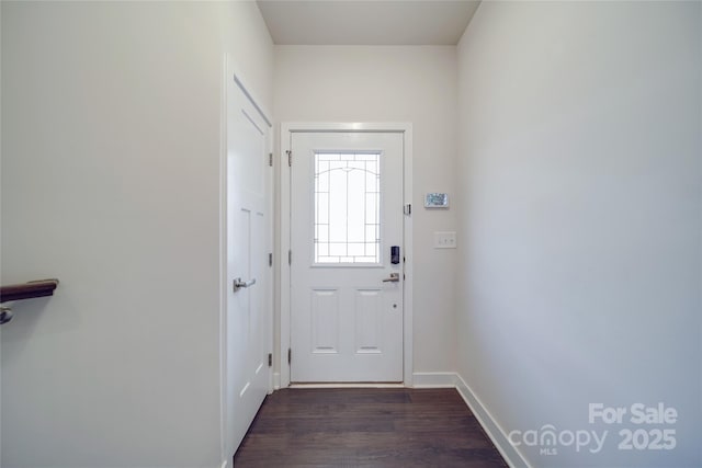 doorway with dark wood finished floors and baseboards