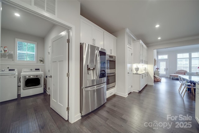 kitchen featuring stainless steel appliances, washing machine and clothes dryer, healthy amount of natural light, white cabinetry, and recessed lighting