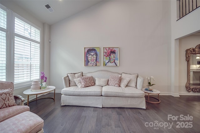 living room with wood finished floors, baseboards, and high vaulted ceiling