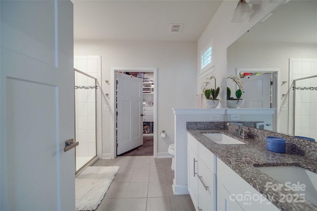 bathroom with a stall shower, tile patterned flooring, and a spacious closet