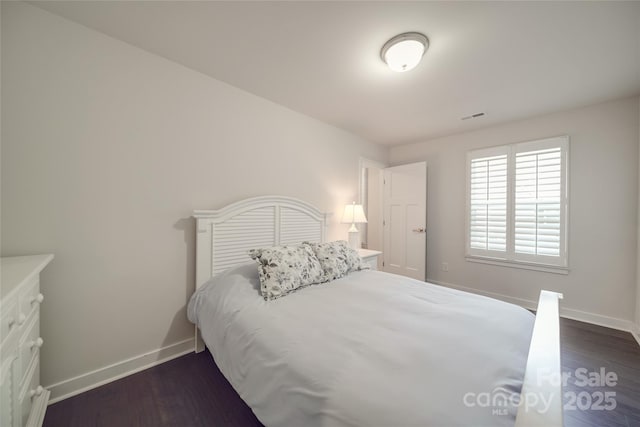 bedroom featuring baseboards and dark wood-style flooring