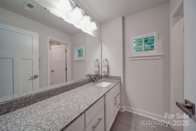 bathroom featuring tile patterned flooring, baseboards, and vanity