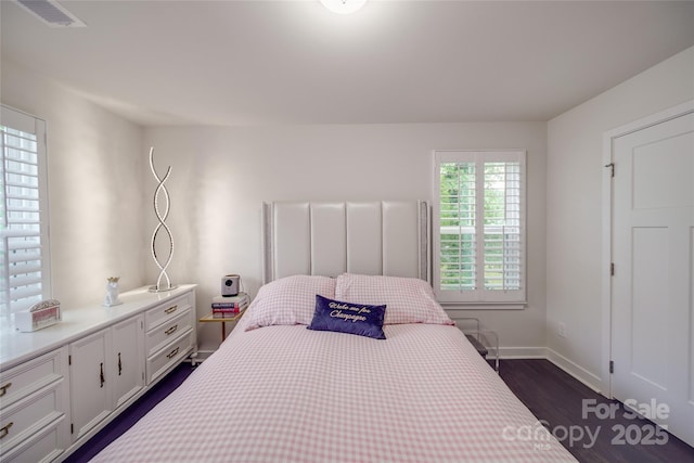 bedroom featuring dark wood finished floors and baseboards