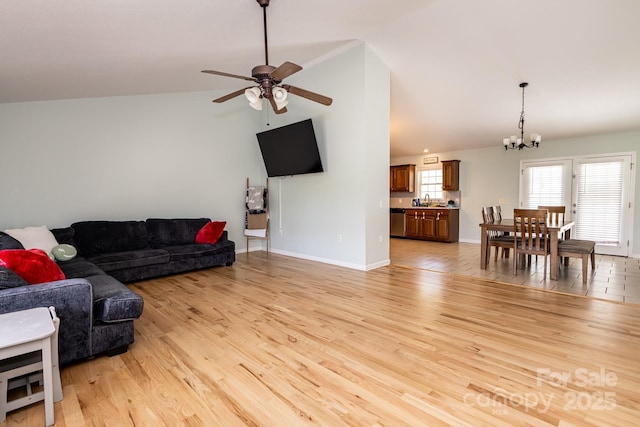living area with lofted ceiling, baseboards, light wood-type flooring, and ceiling fan with notable chandelier