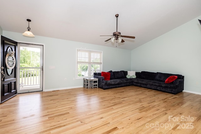 living room featuring a ceiling fan, plenty of natural light, light wood-style flooring, and lofted ceiling