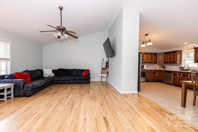 living room with vaulted ceiling, ceiling fan, light wood-style flooring, and baseboards