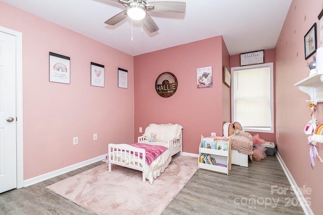 bedroom with wood finished floors, baseboards, and ceiling fan