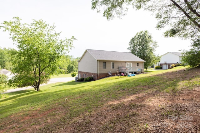 back of house with a deck and a lawn
