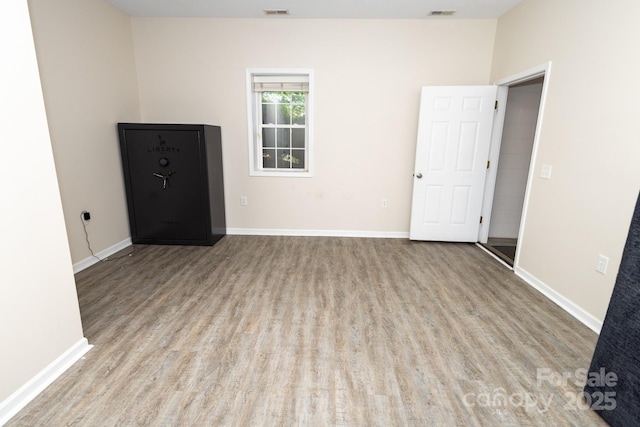 spare room with visible vents, wood finished floors, and baseboards