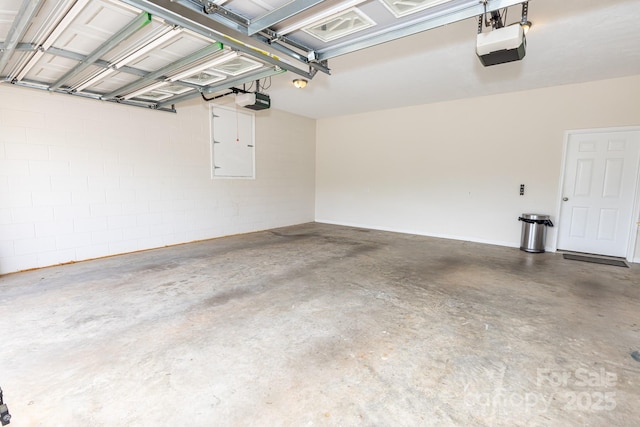 garage featuring concrete block wall and a garage door opener