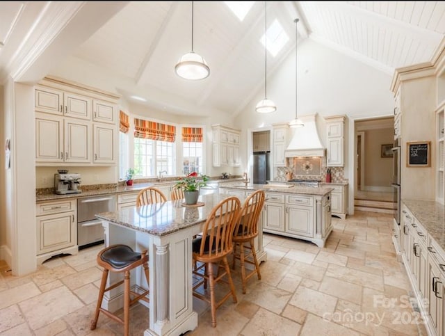 kitchen with cream cabinets, a kitchen island, and stone tile flooring