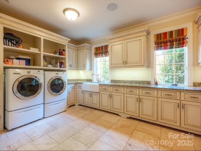 laundry room with cabinet space, independent washer and dryer, crown molding, and a sink