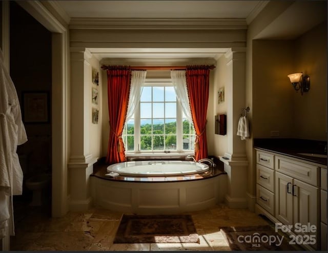 bathroom with a garden tub, baseboards, vanity, and crown molding