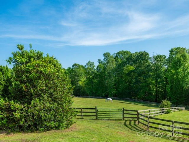 exterior space featuring a rural view, a yard, and fence