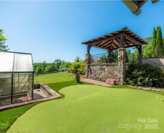 view of yard with an outdoor structure, a greenhouse, and fence