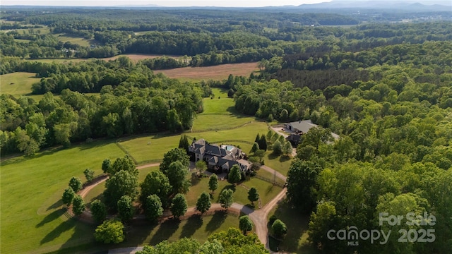 drone / aerial view featuring a rural view and a view of trees