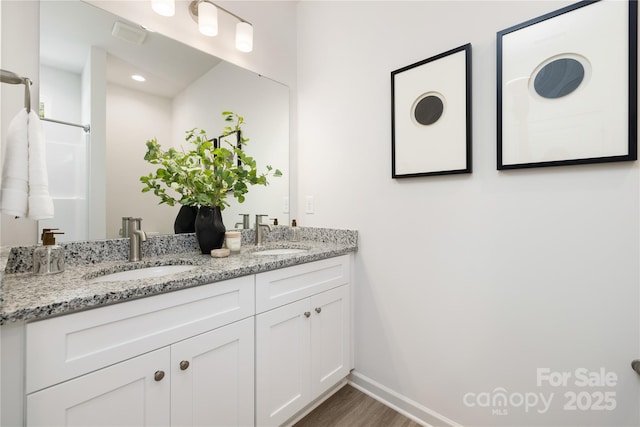401 Groves St, Lowell, NC 28098 - bathroom with baseboards, wood finished floors, and double vanity