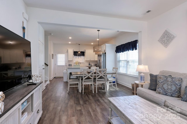 living area featuring plenty of natural light, baseboards, dark wood-style flooring, and recessed lighting