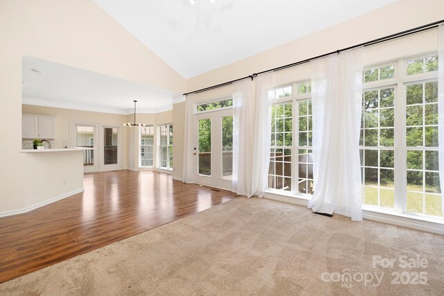 1465 Porters Ct, Concord, NC 28025 - unfurnished living room featuring a chandelier, wood finished floors, high vaulted ceiling, and baseboards