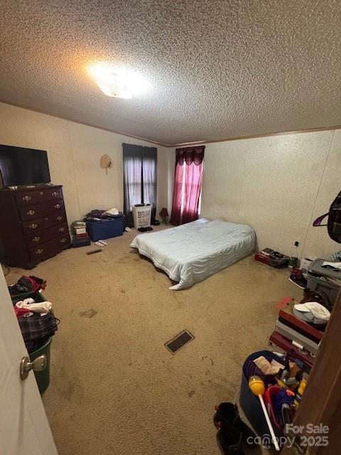 bedroom featuring a textured ceiling, carpet, and visible vents