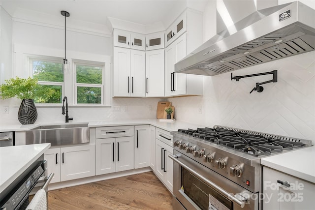 2224 Highland St, Charlotte, NC 28208 - kitchen featuring wall chimney exhaust hood, stainless steel range, a sink, light countertops, and white cabinets