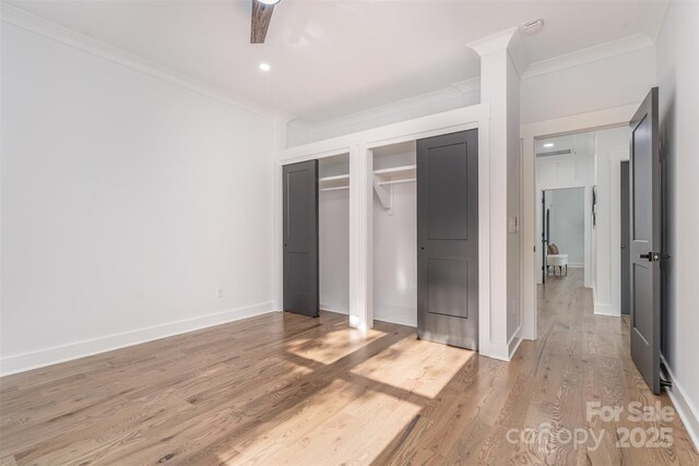2224 Highland St, Charlotte, NC 28208 - unfurnished bedroom with ornamental molding, two closets, light wood-type flooring, recessed lighting, and baseboards