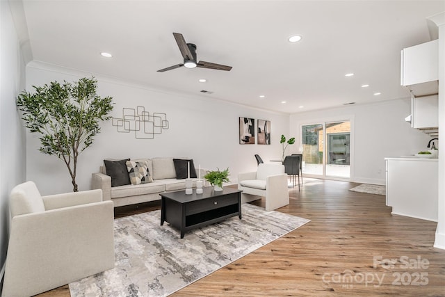 2224 Highland St, Charlotte, NC 28208 - living room featuring ceiling fan, light wood-style flooring, recessed lighting, ornamental molding, and baseboards