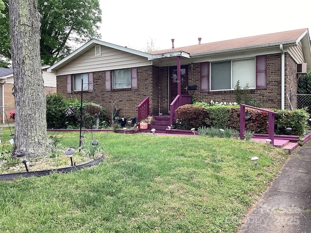 single story home featuring fence, a front lawn, and brick siding