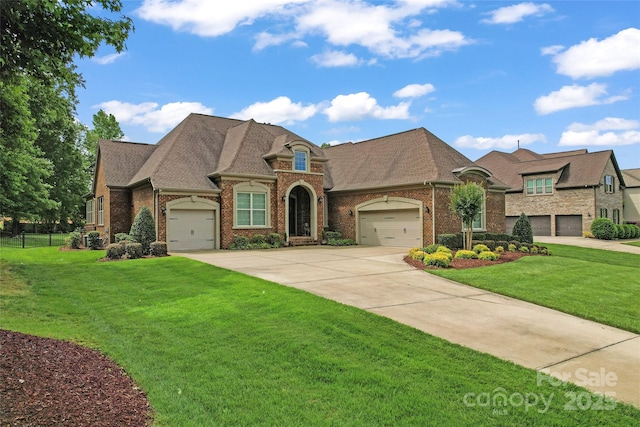 french country style house with brick siding, concrete driveway, an attached garage, and a shingled roof