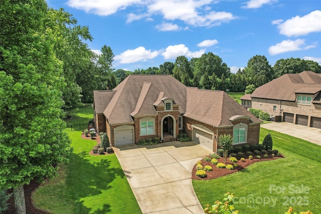 1400 Delaney Dr, Matthews, NC 28104 - french country home featuring brick siding, a front lawn, concrete driveway, and roof with shingles