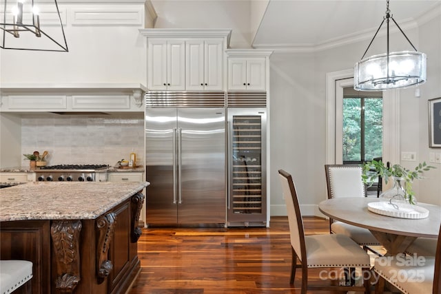 kitchen featuring a chandelier, stainless steel appliances, beverage cooler, decorative backsplash, and crown molding