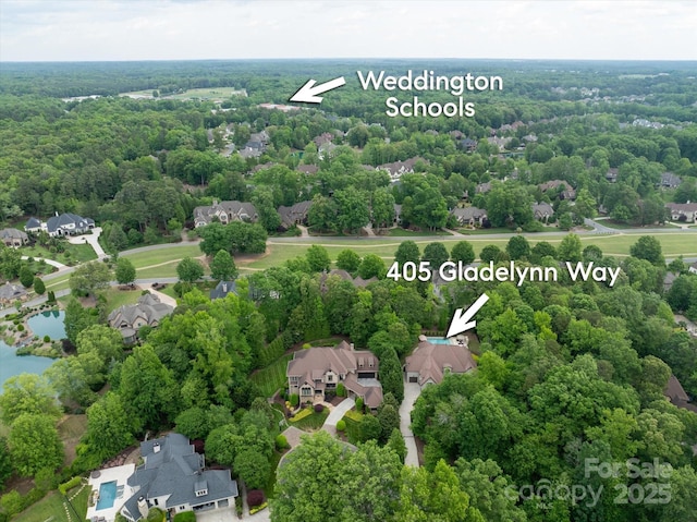 aerial perspective of suburban area featuring a heavily wooded area