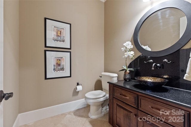 bathroom featuring tile patterned flooring, toilet, vanity, and baseboards