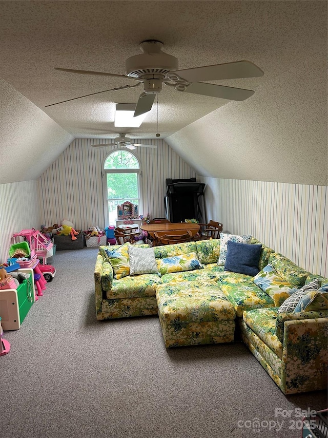 recreation room featuring a textured ceiling, a ceiling fan, lofted ceiling, and carpet