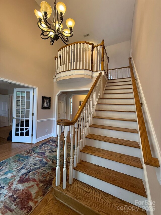 504 Johnsfield Rd, Shelby, NC 28150 - stairs featuring a chandelier, wood finished floors, a high ceiling, and baseboards