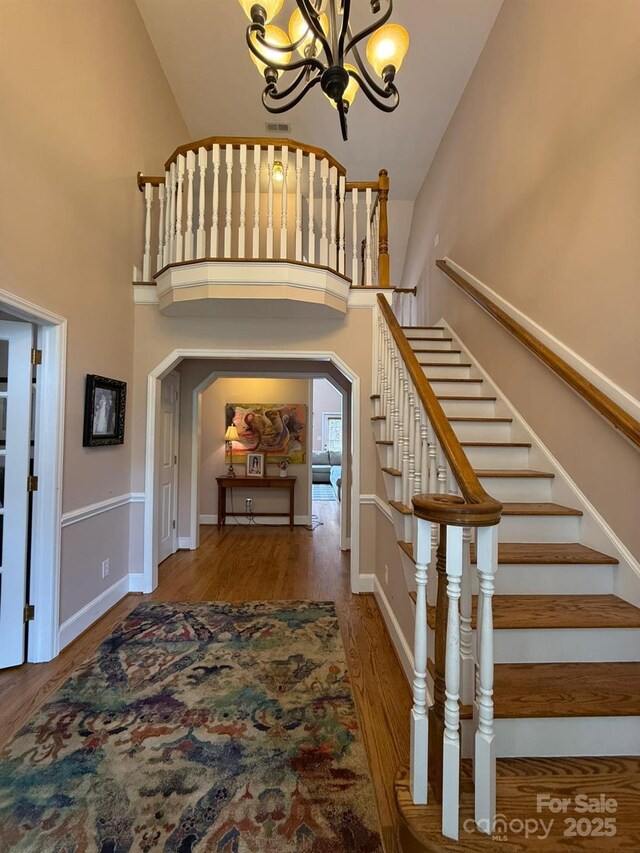 504 Johnsfield Rd, Shelby, NC 28150 - stairway featuring a chandelier, wood finished floors, a high ceiling, and baseboards