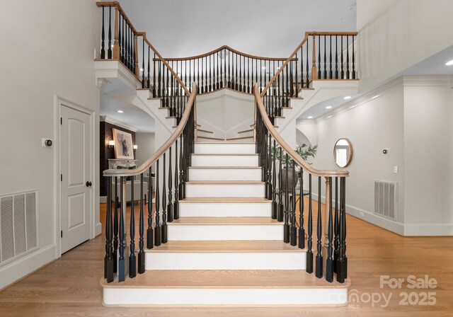 4429 Cameron Oaks Dr, Charlotte, NC 28211 - stairs featuring a towering ceiling, baseboards, visible vents, and wood finished floors