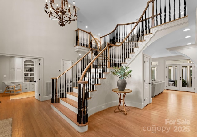 4429 Cameron Oaks Dr, Charlotte, NC 28211 - stairs with wood finished floors, visible vents, a towering ceiling, arched walkways, and a chandelier