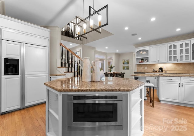 4429 Cameron Oaks Dr, Charlotte, NC 28211 - kitchen featuring a center island, white cabinetry, open shelves, paneled built in fridge, and light wood-style floors